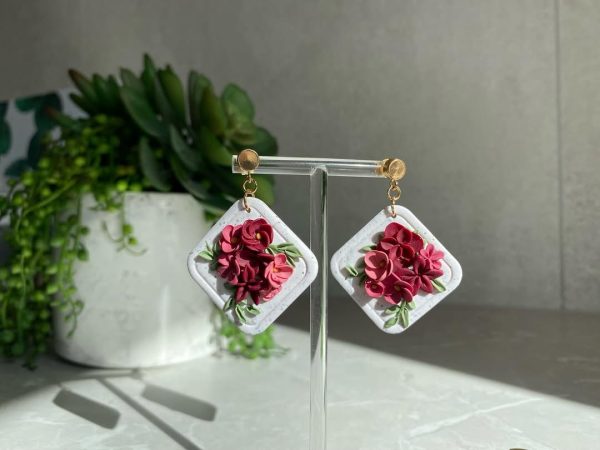 pink floral earrings on white background